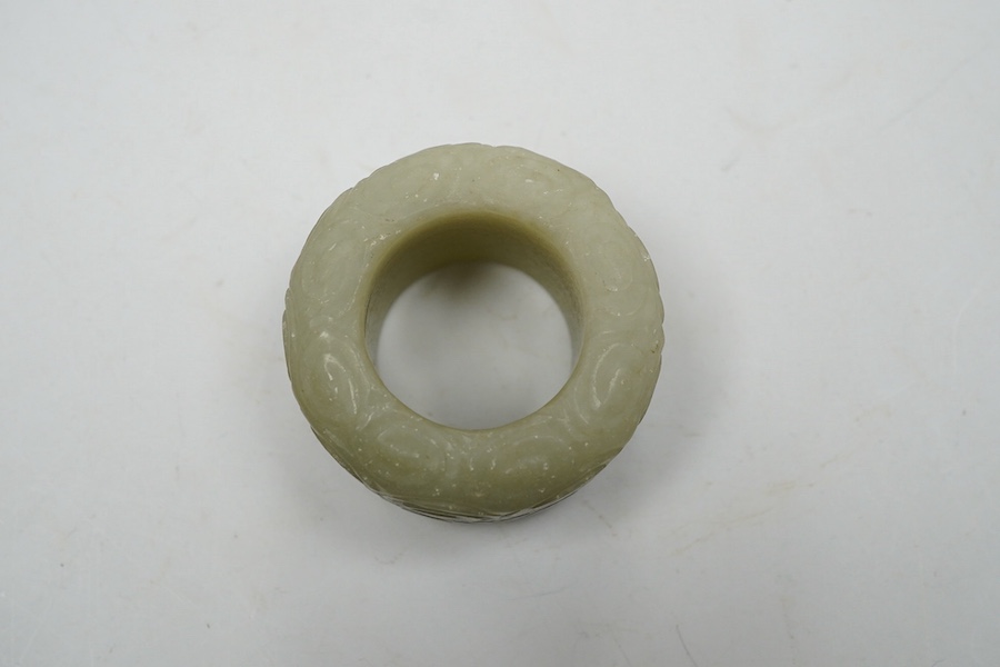 A Chinese celadon jade 'cloud' thumb ring, 4cm diameter. Condition - good